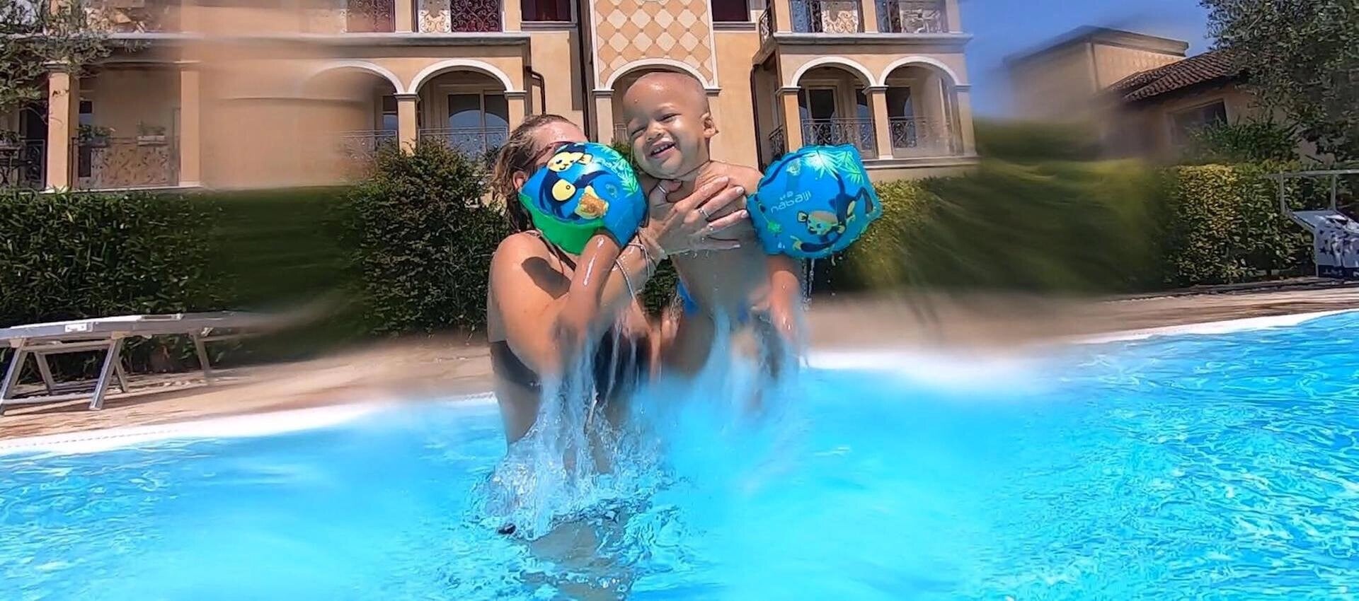 A baby and mother in a swimming pool.
